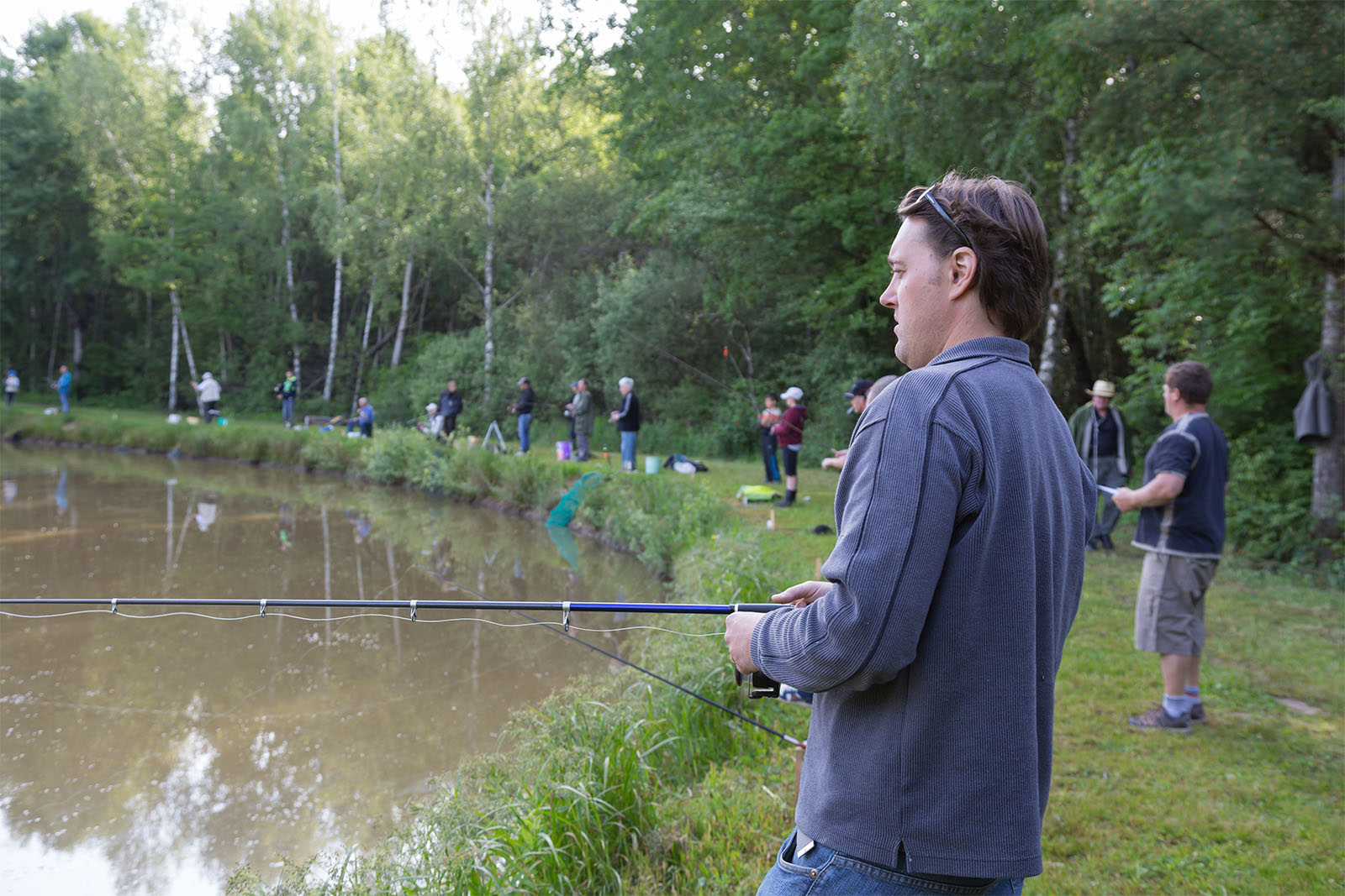 Anglers lined up on pegs around a lake for a match