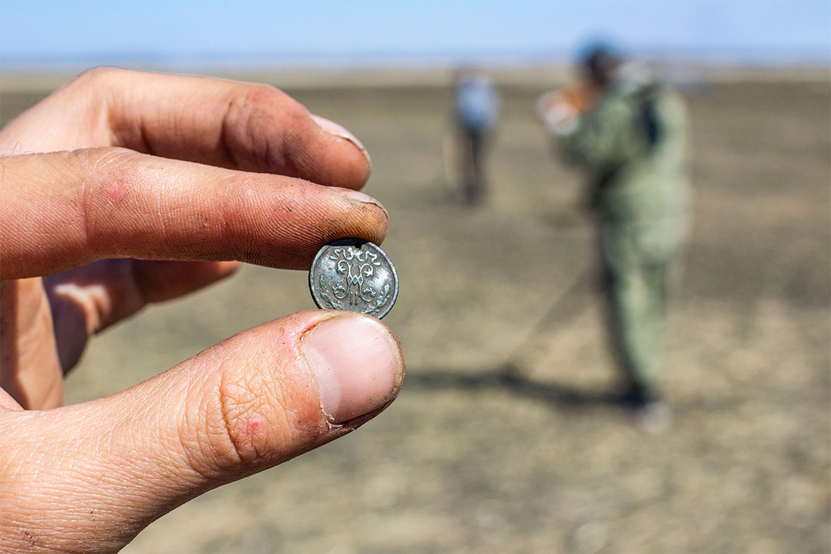 Detectorist holding a coin found in the field