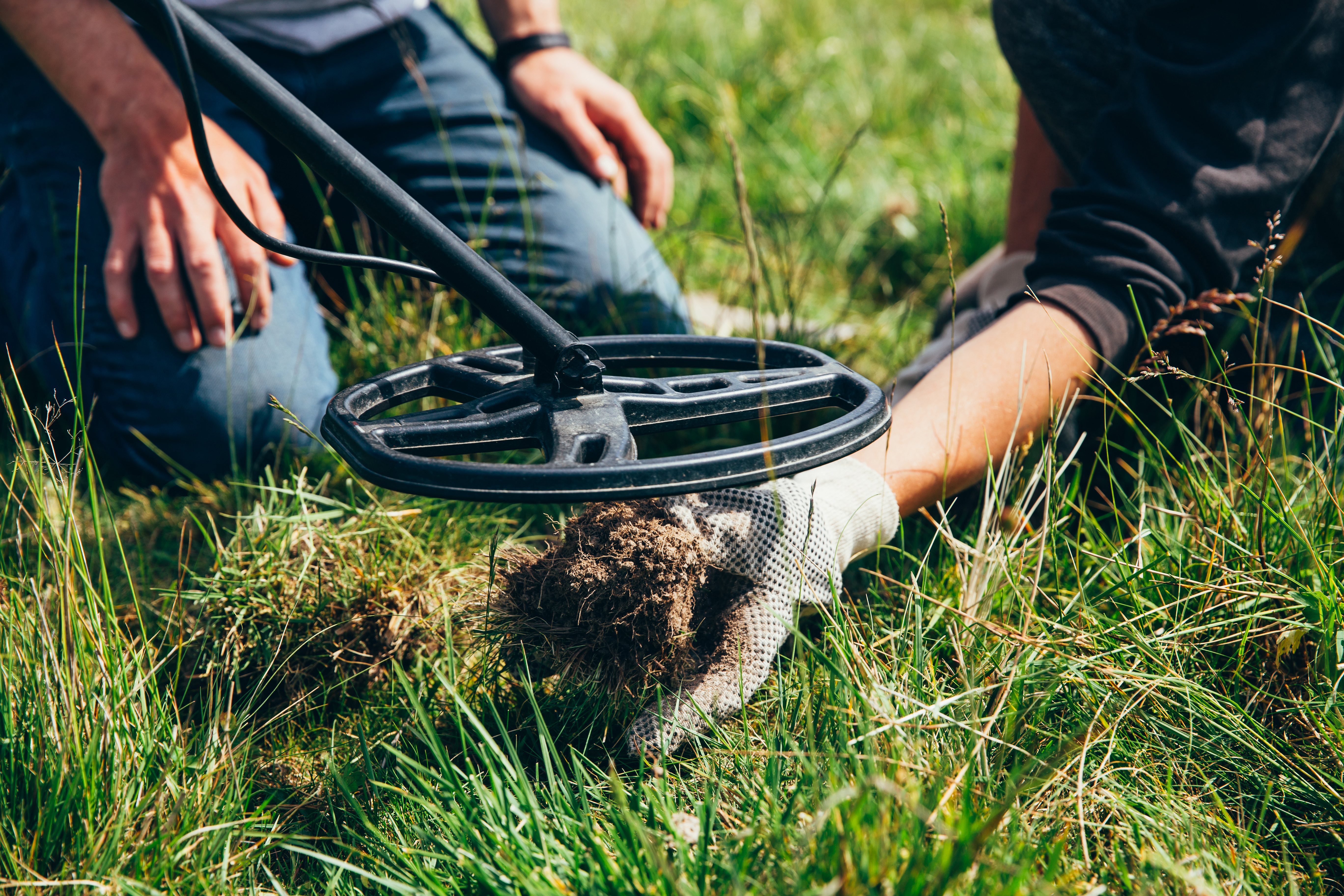 Metal detector sweeping over grass